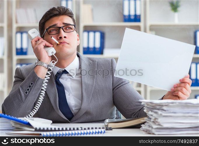 Businessman smoking at work in office holding a blank message board. Businessman smoking at work in office holding a blank message bo