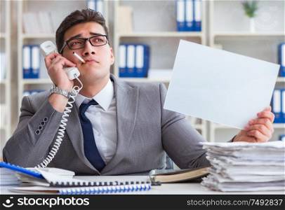 Businessman smoking at work in office holding a blank message board. Businessman smoking at work in office holding a blank message bo