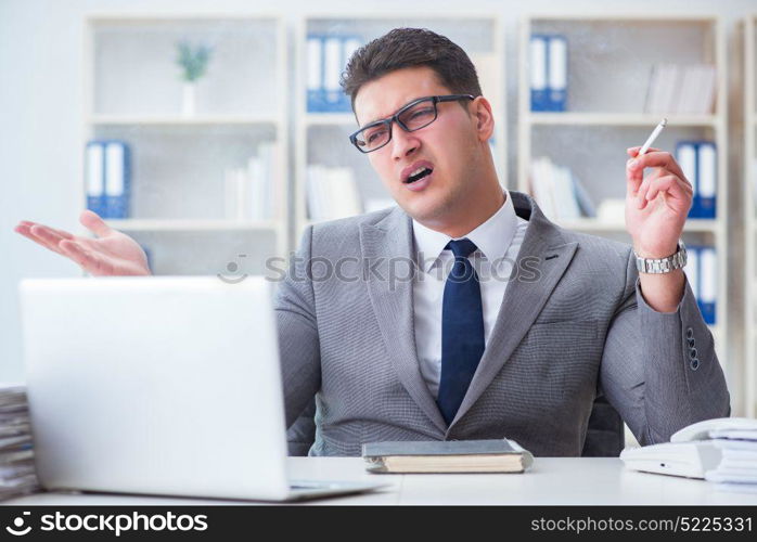 Businessman smoking in office at work