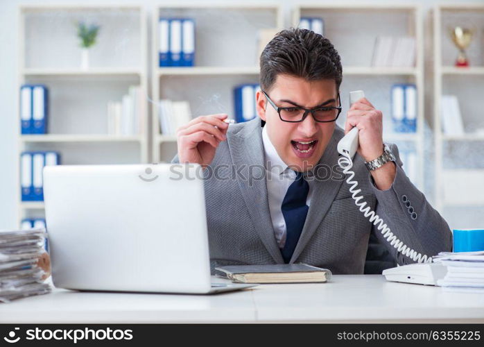 Businessman smoking in office at work