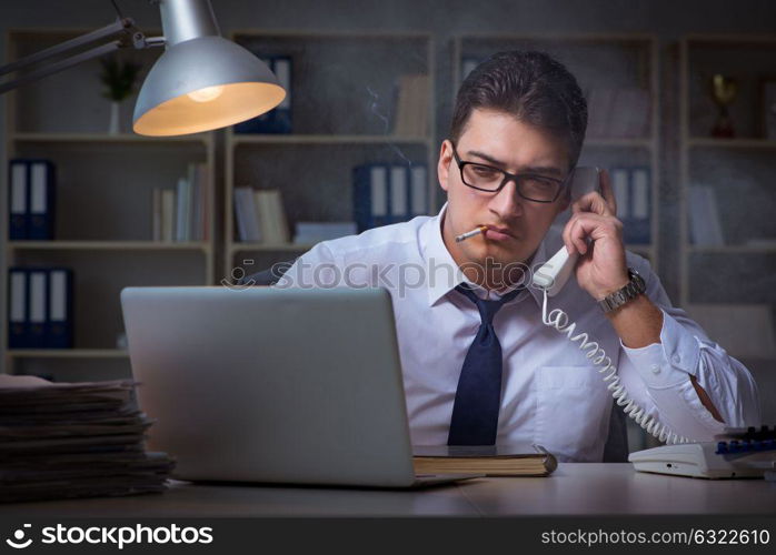 Businessman speaking on phone and smoking in office