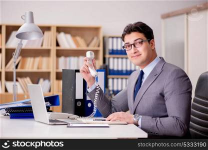 Businessman speaking on phone in office
