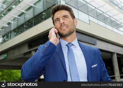 businessman speaks on the phone outdoors