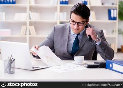 Businessman spilling coffee on important documents