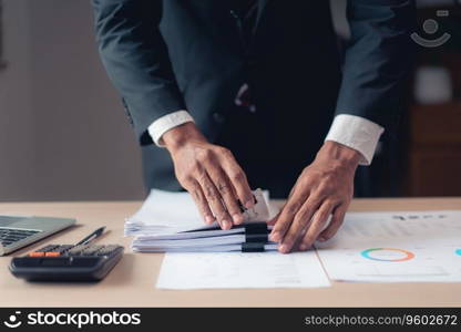 Businessman stacking document after checking financial and accounting report of business project.