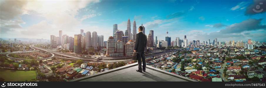 Businessman stand at rooftop looking great cityscape view and thinking business plan of the future .