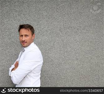 Businessman standing against concrete wall
