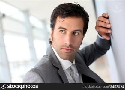 Businessman standing against wall