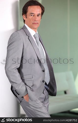 Businessman standing against wall