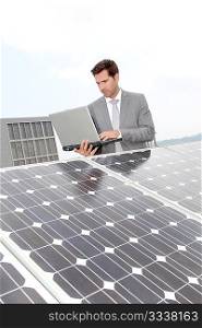 Businessman standing by solar panels