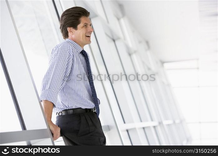 Businessman standing in corridor laughing