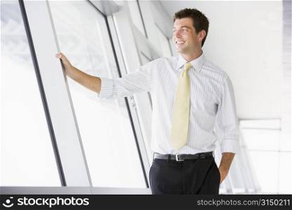 Businessman standing in corridor smiling