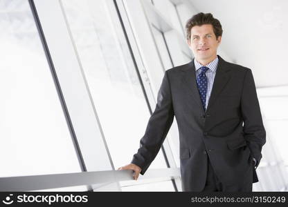 Businessman standing in corridor smiling