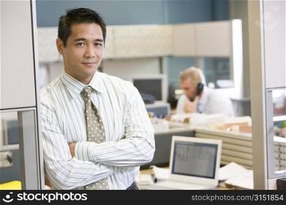 Businessman standing in cubicle