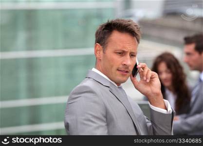 Businessman standing in front of offices outside