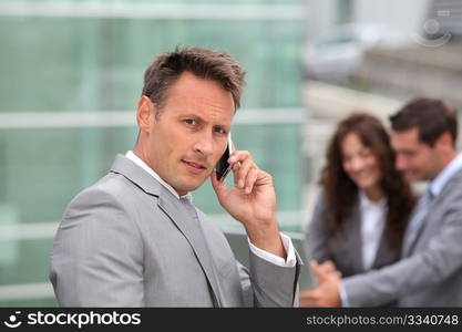 Businessman standing in front of offices outside