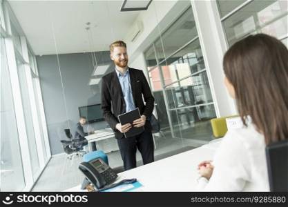 Businessman standing in front of the desk in the office