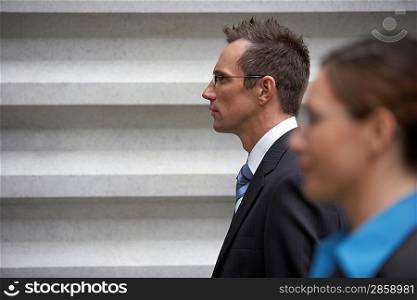 Businessman standing in front of wall profile portrait with businesswoman