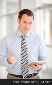 Businessman standing in hall with electronic tab