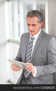 Businessman standing in hall with electronic tab