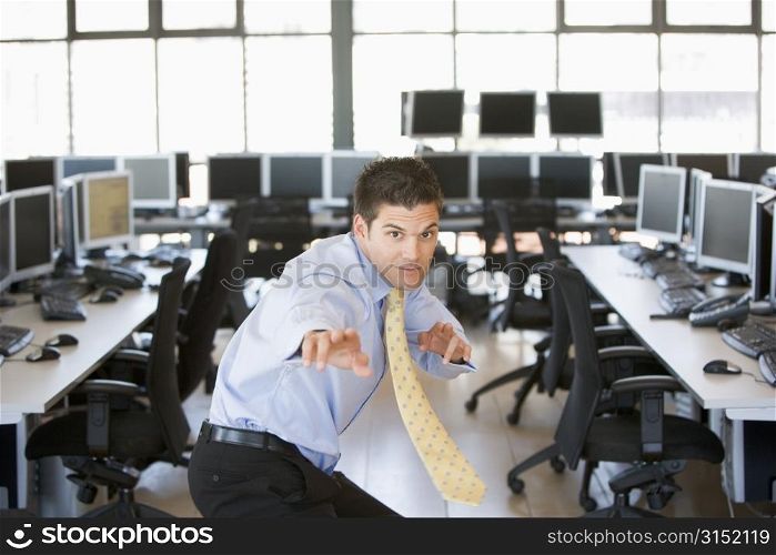 Businessman standing in karate stance in computer room