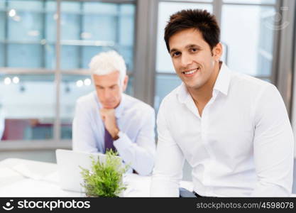 Businessman standing in office smiling at camera. Success and professionalism in person