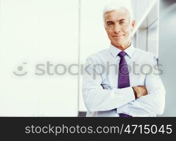 Businessman standing in office smiling at camera. Success and professionalism in person