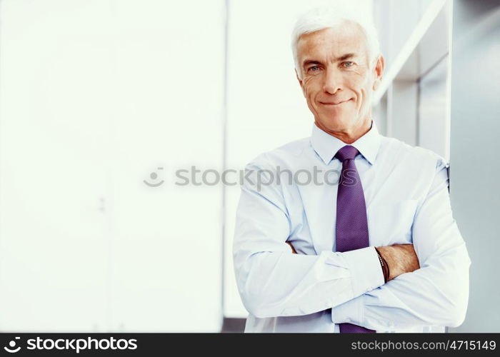 Businessman standing in office smiling at camera. Success and professionalism in person