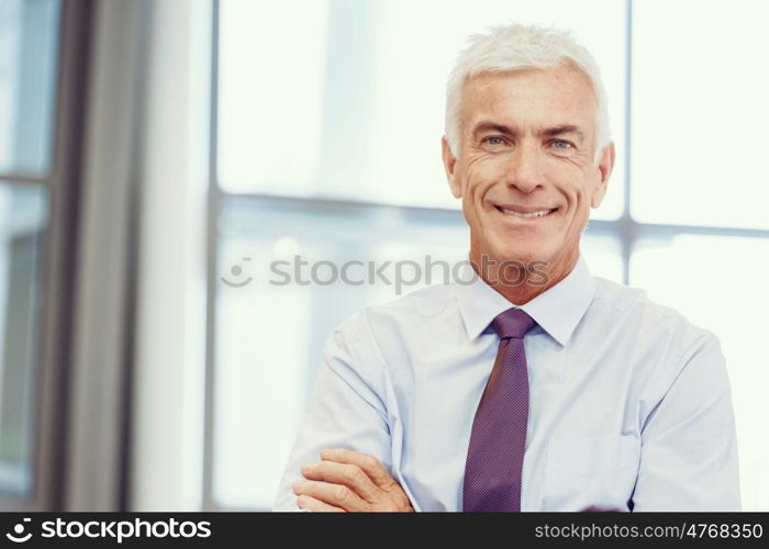 Businessman standing in office smiling at camera. Success and professionalism in person