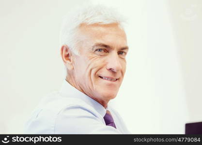 Businessman standing in office smiling at camera. Success and professionalism in person