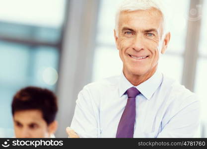 Businessman standing in office smiling at camera. Success and professionalism in person