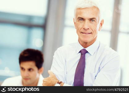 Businessman standing in office smiling at camera. Success and professionalism in person