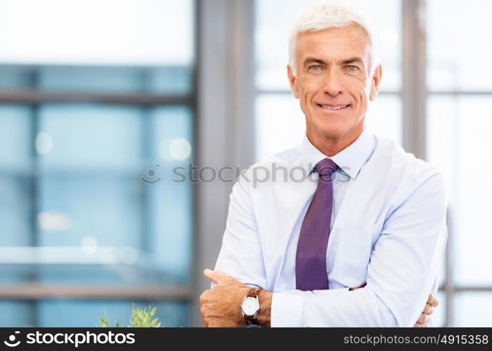 Businessman standing in office smiling at camera. Success and professionalism in person