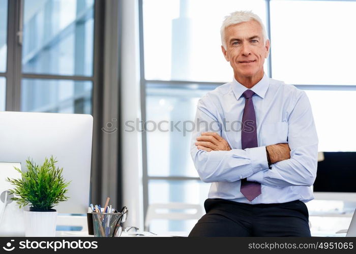 Businessman standing in office smiling at camera. Success and professionalism in person