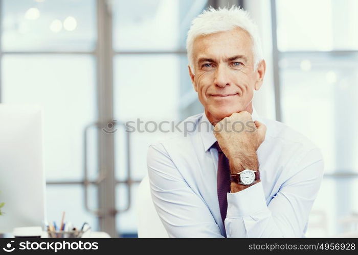 Businessman standing in office smiling at camera. Success and professionalism in person