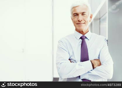 Businessman standing in office smiling at camera. Success and professionalism in person