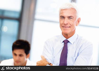 Businessman standing in office smiling at camera. Success and professionalism in person