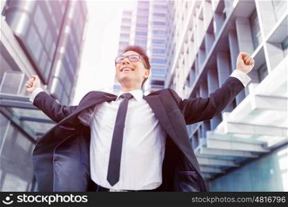 Businessman standing in street with his arms open. I have done it