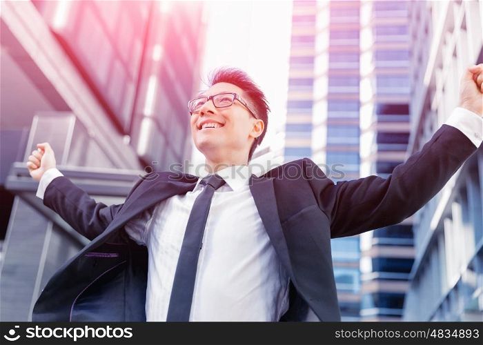 Businessman standing in street with his arms open. I have done it