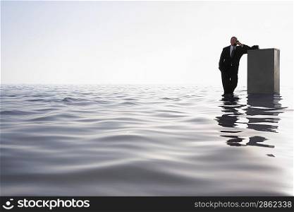 Businessman Standing in the Ocean Talking on the Telephone