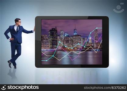 Businessman standing next to tablet computer in business concept