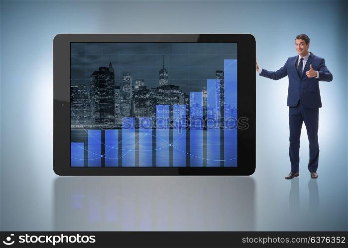 Businessman standing next to tablet computer in business concept