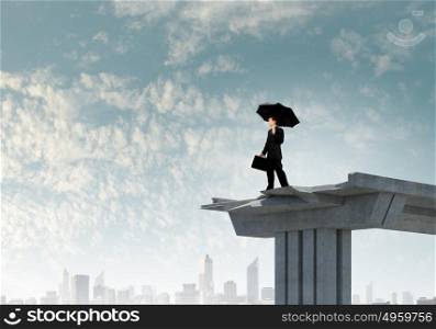 Businessman standing on bridge. Young businessman with umbrella standing on bridge