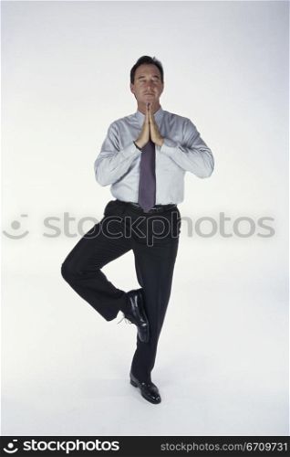 Businessman standing on one leg