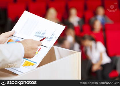 Businessman standing on stage and reporting for audience