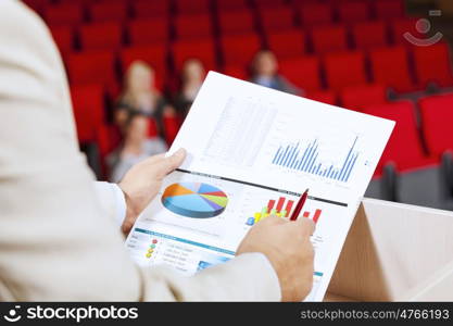 Businessman standing on stage and reporting for audience