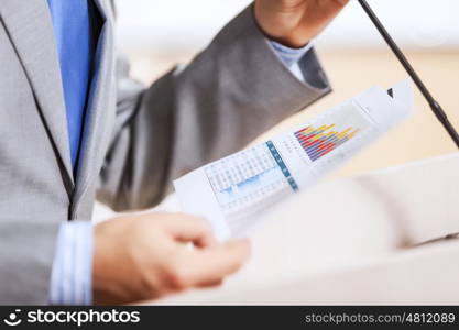 Businessman standing on stage and reporting for audience