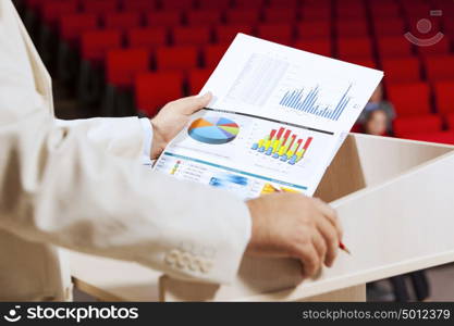 Businessman standing on stage and reporting for audience