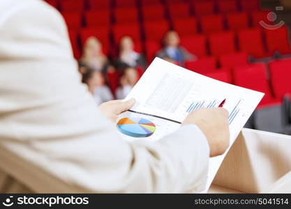 Businessman standing on stage and reporting for audience