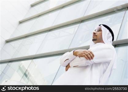Businessman standing outdoors by building (selective focus)